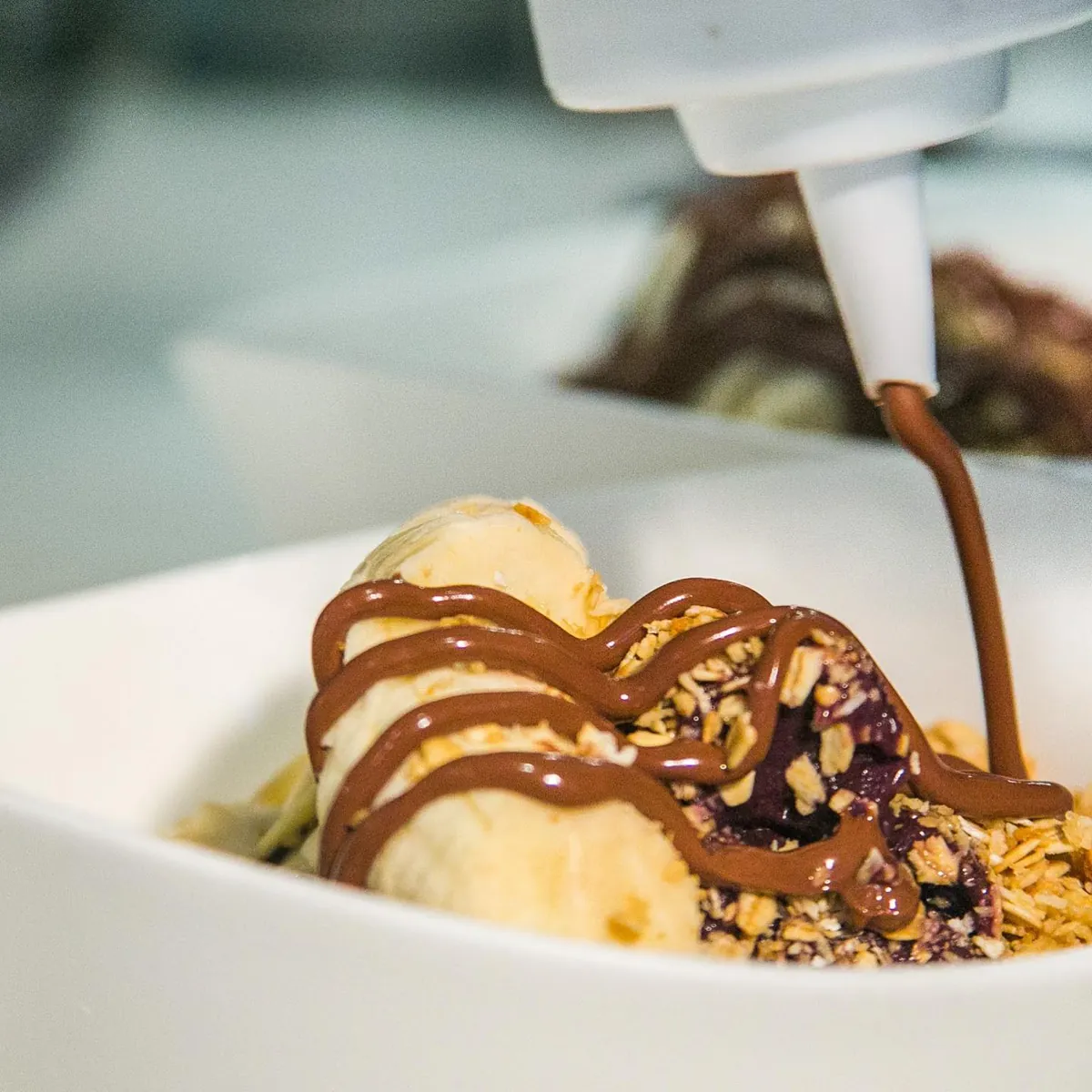A decorated dessert bowl layered with fruit and chocolate