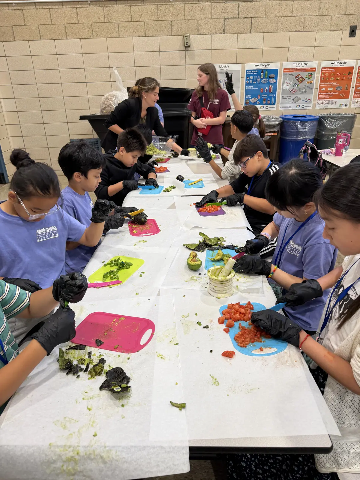 A class of students prepping fresh ingredients at a long work table